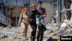 Employees leave a restaurant building hit by recent shelling that local Russian-installed authorities called a Ukrainian military strike in Donetsk, Russian-controlled Ukraine, May 11, 2024.