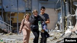 Sejumlah karyawan meninggalkan restoran yang terkena penembakan baru-baru ini yang oleh pihak berwenang setempat – yang ditunjuk Rusia – disebut sebagai serangan militer Ukraina di Donetsk, Ukraina yang dikuasai Rusia, Sabtu, 11 Mei 2024. (Foto: Alexander Ermochenko/Reuters)