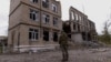 A police officer stands in front of a damaged building, amid Russia's attack on Ukraine, in the town of Avdiivka, Donetsk region, Ukraine, Oct. 17, 2023. 