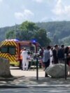 Medics and emergency personnel work at the site where a person wounded four children and an adult in a knife attack in a park in Annecy, France, June 8, 2023.