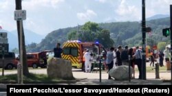 Medics and emergency personnel work at the site where a person wounded four children and an adult in a knife attack in a park in Annecy, France, June 8, 2023.