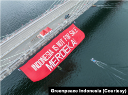 Organisasi masyarakat sipil dan warga Penajam Paser Utara, Kalimantan Timur, membentangkan kain merah bertuliskan 'Indonesia is not for sale, Merdeka!' (Foto: Courtesy/Greenpeace Indonesia)