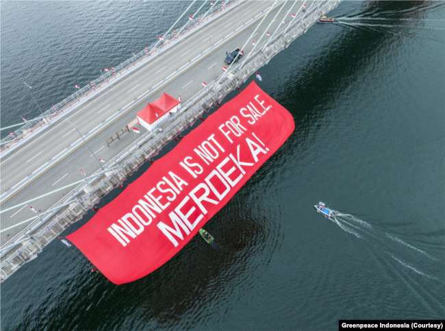 Organisasi masyarakat sipil dan warga Penajam Paser Utara, Kalimantan Timur, membentangkan kain merah bertuliskan 'Indonesia is not for sale, Merdeka!' (Foto: Courtesy/Greenpeace Indonesia)