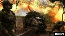 Ukrainian servicemen of the 10th Mountain Assault Brigade 'Edelweiss' fire a D-30 howitzer towards Russian troops at a position in a front line near the town of Soledar, Donetsk region, May 6, 2023. 