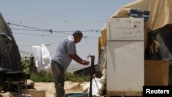 El palestino Jihad Nuwaja se lava las manos fuera de su tienda de campaña en la aldea de Susiya, al sur de la ciudad de Hebrón, en Cisjordania, el 20 de julio de 2015.