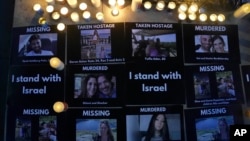 Pictures of the dead, missing and those taken hostage are displayed beside candles during the Jewish Community Vigil for Israel in London, Britain, Oct. 9, 2023.
