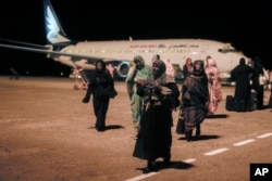 सऊदी अरब के जेद्दाह में फंसे सूडानी, गुरुवार, 11 मई, 2023 को पोर्ट सूडान हवाई अड्डे पर पहुंचे।