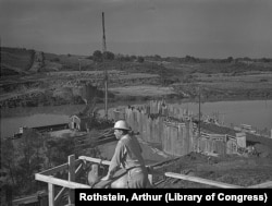 A worker views construction of the Fort Loudon Dam in Tennessee, built by the TVA to bring electricity and flood control to the Tennessee Valley. Photo taken June 1942.