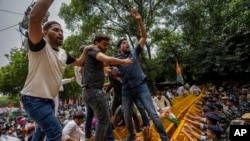 Supporters of India's opposition Congress party climb police barricades during a protest in New Delhi, India, against the government led by Narendra Modi, Aug. 8, 2023.