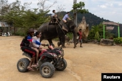 FILE - A Chinese tourist rides on an elephant in a jungle park in Phuket, Thailand, Jan. 20, 2023.