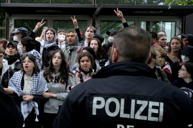 Protesters face German police officers during a pro-Palestinians demonstration by the group "Student Coalition Berlin" at the 'Freie Universität Berlin' in Berlin, Germany, Tuesday, May 7, 2024. (AP Photo/Markus Schreiber)