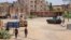 Sudanese Army soldiers walk near armored vehicles positioned on a street in southern Khartoum, May 6, 2023, amid ongoing fighting between the Army and the paramilitary Rapid Support Forces.
