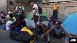 Policías desalojan a migrantes de un campamento instalado frente al Instituto Nacional de Migración (INM) en Ciudad Juárez, estado de Chihuahua, México, el 22 de mayo de 2023. [Foto: AFP]