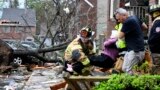 Firefighters carry a woman out of a condo after her complex was damaged by a tornado, March 31, 2023 in Little Rock, Ark. Tornadoes damaged homes, vehicles and uprooted trees.