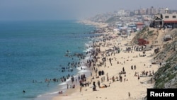Warga Palestina menikmati suasana di pantai Gaza pada hari yang panas di tengah konflik antara Israel dan Hamas di kota Deir Al-Balah, Gaza tengah pada 17 April 2024. (Ramadan Abed/Reuters)