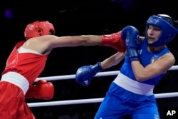 FILE - Algeria's Imane Khelif, left, fights Italy's Angela Carini in their women's 66-kilogram preliminary boxing match at the 2024 Summer Olympics on Aug. 1, 2024, in Paris, France. (AP Photo/John Locher)