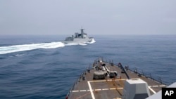 ໃນພາບນີ້ສະໜອງໂດຍກອງທັບເຮືອສະຫະລັດ, ສະແດງໃຫ້ເຫັນ ກຳປັ່ນລົບ USS Chung-Hoon ທີ່ກຳລັງຕິດຕາມມເບິ່ງກຳປັ່ນລົບຂອງຈີນ ດຳເນີນການໃນສິ່ງທີ່ຕົນ ເອີ້ນວ່າ ການລ້ຽວກຳປັ່ນທີ່ "ບໍ່ປອດໄພ” ຂອງຈີນ ໃນຊ່ອນແຄບໄຕ້ຫວັນ, ວັນທີ 3 ມິຖຸນາ 2023. 
