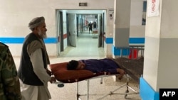 Men shift a wounded man inside a hospital in Mazar-i-Sharif on March 9, 2023, following a suicide attack at the office of the Taliban governor of Afghanistan's Balkh province. 