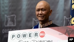 Cheng "Charlie" Saephan holds display check during a news conference where it was revealed that he was one of the winners of the $1.3 billion Powerball jackpot at the Oregon Lottery headquarters, April 29, 2024, in Salem, Ore. (AP Photo/Jenny Kane)