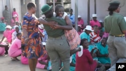 A freed female prisoner hugs a prison officer after being released from Chikurubi maximum prison on the outskirts of Harare, Zimbabwe, May, 19, 2023. 