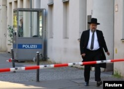 Član jevrejske zajednice prolazi pored sinagoge u Berlinu nakon što su na ovaj objekat bačeni Molotovljevi kokteli. (Foto: REUTERS/Fabrizio Bensch)