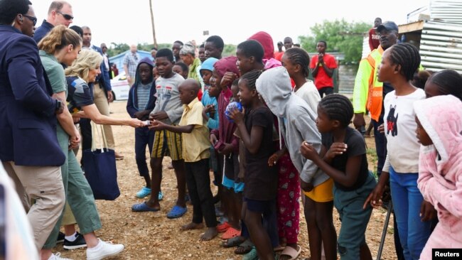 U.S. first lady Jill Biden hands out sweets to children outside the Hope Initiatives Southern Africa, in Windhoek, Namibia, Feb. 23, 2023.