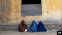 FILE- Afghan women wait to receive food rations distributed by a humanitarian aid group, in Kabul, Afghanistan, May 23, 2023. 
