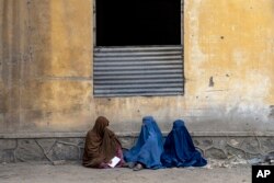 FILE- Afghan women wait to receive food rations distributed by a humanitarian aid group, in Kabul, Afghanistan, May 23, 2023.