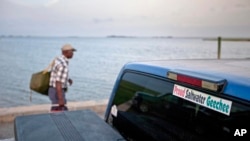 FILE - A sticker celebrating Geechee heritage is seen on a pickup truck, June 10, 2013, as passengers board a ferry to the mainland from Sapelo Island, Ga.