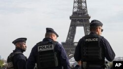 Police officers patrol the Trocadero plaza near the Eiffel Tower in Paris, Oct. 17, 2023. 