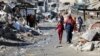 Palestinci prolaze pored ruševina kuća uništenih tokom izraelske vojne ofanzive, tokom sukoba između Izraela i Hamasa, u gradu Gaza, 20. marta 2024. 