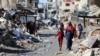 Палестинці йдуть повз руїни будинків, зруйнованих під час військового наступу Ізраїлю, на тлі конфлікту між Ізраїлем і ХАМАСом, Газа, 20 березня 2024 року