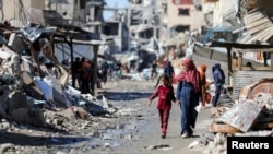 Palestinci prolaze pored ruševina kuća uništenih tokom izraelske vojne ofanzive u gradu Gaza, 20. marta 2024.