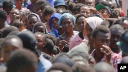 FILE - People line up to receive food at a shelter for families displaced by gang violence, in Port-au-Prince, Haiti, March 14, 2024