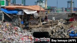 Sampah plastik rumah tangga yang dibuang warga nyaris menyumbat saluran air di Jakarta pada 22 April 2020. (Foto: AFP/Bay Ismoyo)
