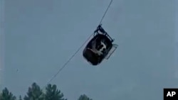 En esta imagen tomada del video, un teleférico que transporta a seis niños y dos adultos cuelga cientos de metros sobre el suelo en el remoto distrito de Battagram, Khyber Pakhtunkhwa, Pakistán, el martes 22 de agosto de 2023. 