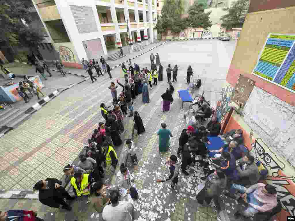 Voters collect food vouchers from members of Sissi-aligned political parties. Cairo, Egypt, Dec. 11, 2023. (Hamada Elrasam/VOA)