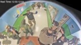 Law enforcement officers stage in a hallway after Salvador Ramos entered Robb Elementary school to kill 19 children and two teachers in Uvalde, Texas, U.S. May 24, 2022 in a still image from surveillance video. 