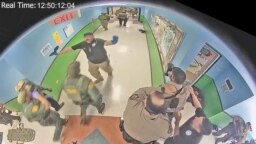 Law enforcement officers stage in a hallway after Salvador Ramos entered Robb Elementary school to kill 19 children and two teachers in Uvalde, Texas, U.S. May 24, 2022 in a still image from surveillance video. 