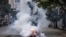 A protester runs away from tear gas fired by police in Nairobi, Kenya, July 16, 2024. 
