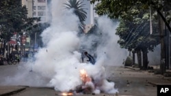 FILE - A protester runs from tear gas fired by police in Nairobi, Kenya, July 16, 2024. Kenya's High Court on Thursday suspended a police ban on protests in the capital, stating citizens have a right to demonstrate peacefully. 