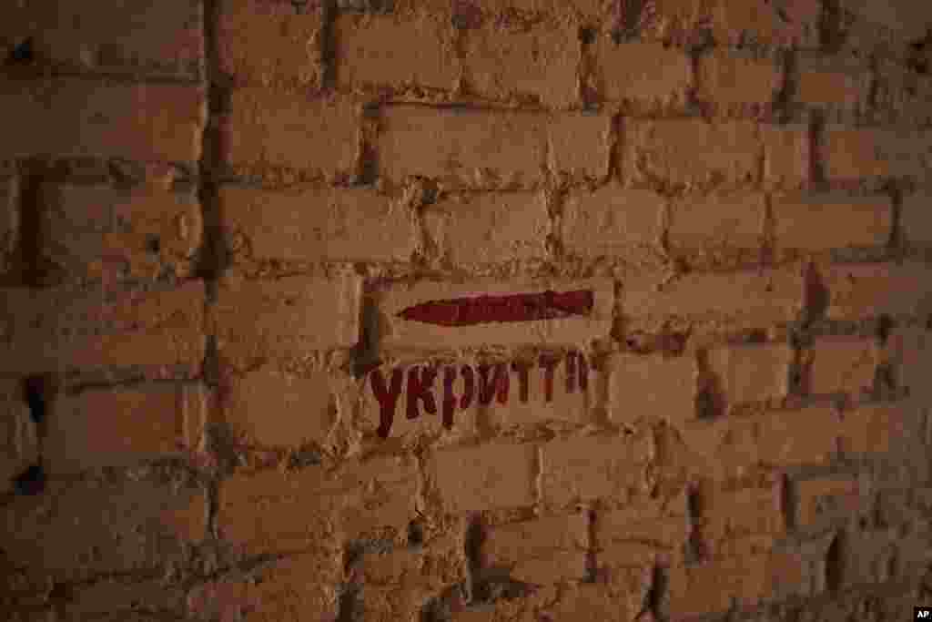 Una señal con la palabra &quot;refugio&quot; en una calle en Kiev, Ucrania, el 11 de marzo de 2023. Hay sacos de arena protegiendo estatuas y barreras antitanque en las calles, trincheras en los bosques cercanos y avisos de minas terrestres en el monte. Las señales pintadas en las paredes indican el refugio más próximo, mientras las sirenas antiaéreas suenan ocasionalmente en la ciudad, que a veces sufre ataques con misiles.&nbsp;