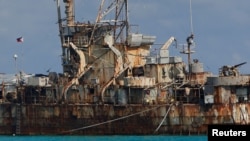 FILE — A Philippine flag flutters over the BRP Sierra Madre, a marooned transport ship that Philippine Marines use as a military outpost in the disputed Second Thomas Shoal, part of the Spratly Islands in the South China Sea, March 30, 2014.