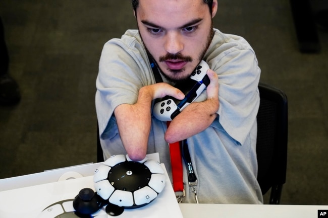 Martin Shane uses a Sony Access controller, left, to play a video game at Sony Interactive Entertainment headquarters Thursday, Sept. 28, 2023, in San Mateo, Calif. (AP Photo/Godofredo A. Vásquez)