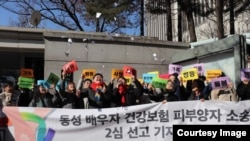 Kim Yong-min dan rekannya, So Seong-wook, merayakan putusan pengadilan yang mengizinkan Kim dimasukkan sebagai tertanggung di bawah program asuransi kesehatan pasangannya, 21 Februari 2023. (Sumber: Kim Yong-min)
