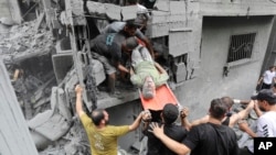 Palestinians carry an injured man out of the destruction following Israeli airstrikes on Gaza City, Oct. 27, 2023.