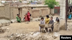 افغانستان کے باگرام صوبے کے ایک گاوں میں سیلاب زدہ علاقے میں بچے جمع ہین فائل فوٹو