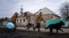 Hennadiy Mazepa and his wife, Natalia Ishkova, walk along the road as they collect wood from houses destroyed by Russian shelling in Chasiv Yar, Ukraine, March 3, 2023.