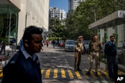 Polisi dan penjaga keamanan swasta berjaga di pintu gerbang sebuah gedung kantor BBC di New Delhi, India, Selasa, 14 Februari 2023. (AP/Altaf Qadri)