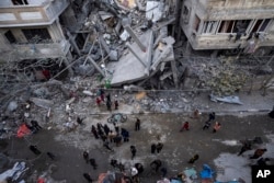 Warga Palestina memeriksa kerusakan bangunan tempat tinggal pasca serangan udara Israel di Rafah, Jalur Gaza selatan, 24 Maret 2024. (Foto: AP)